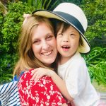 Women hugging child with Down Syndrome.