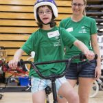 Girl with Down Syndrome Riding a bike in a gym